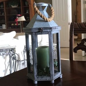 Glass, metal and wood lantern with rope handle.